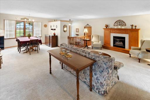 Another view of the spacious living and dining areas, showcasing the open layout, beautiful wood accents, and gas fireplace.