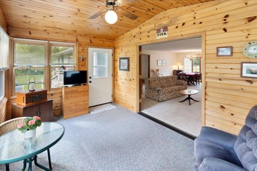 Another view of the inviting porch, showcasing its natural wood finishes, backyard access, and convenient connection to the main living area.
