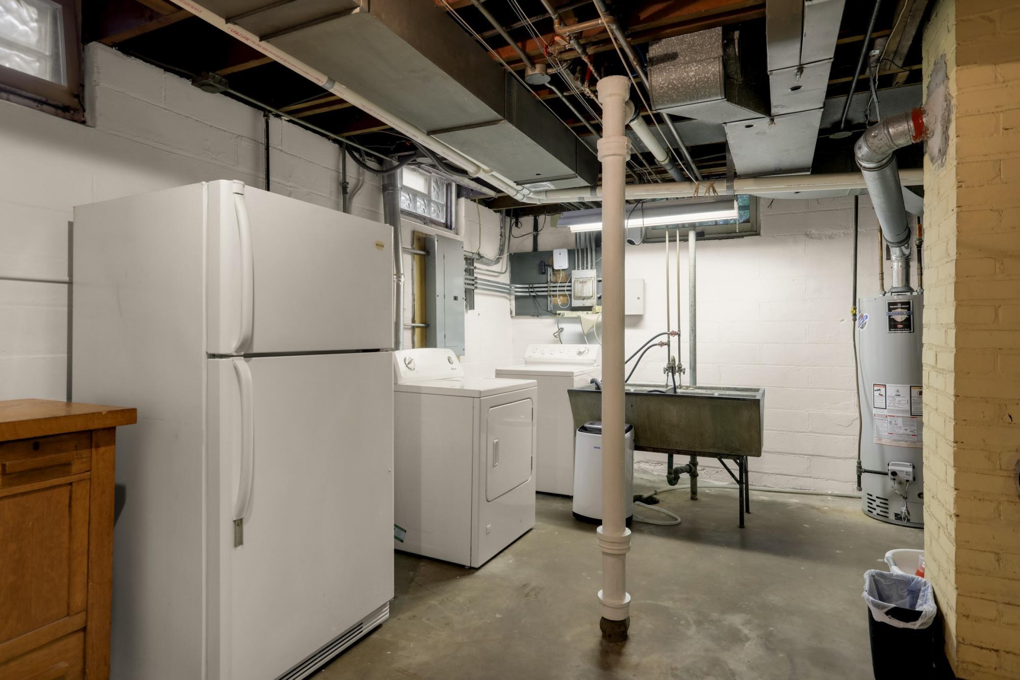 Spotless laundry room with washer, dryer (gas) and extra refrigerator-all stay with the home.
