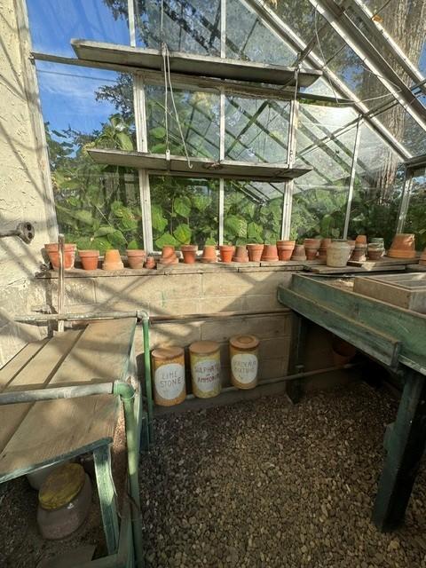 Pots line this unusual outdoor room. Windows everywhere!