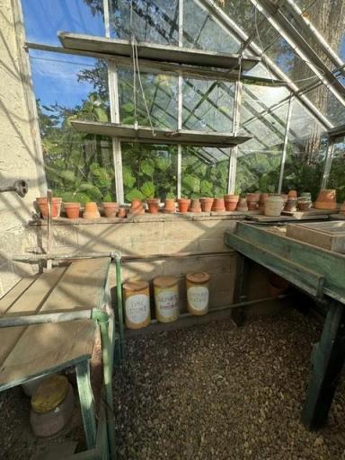 Pots line this unusual outdoor room. Windows everywhere!