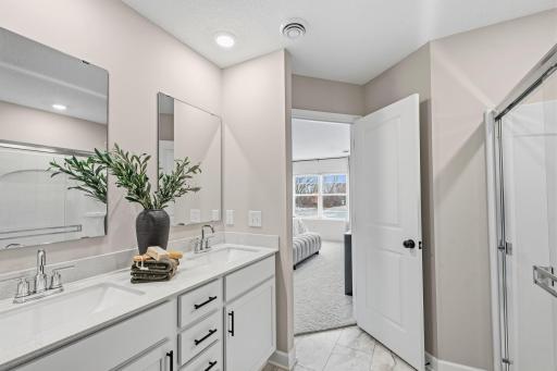 Quartz countertops, MoenÂ® Glyde faucets and dual sinks come together at this impressive vanity