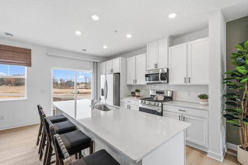(All photos are of the actual model home.) At the focal point of this modern kitchen is a quartz-topped center island to add bar-style seating, complemented by extensive cabinetry room and all-new stainless steel appliances to craft delicious meals.