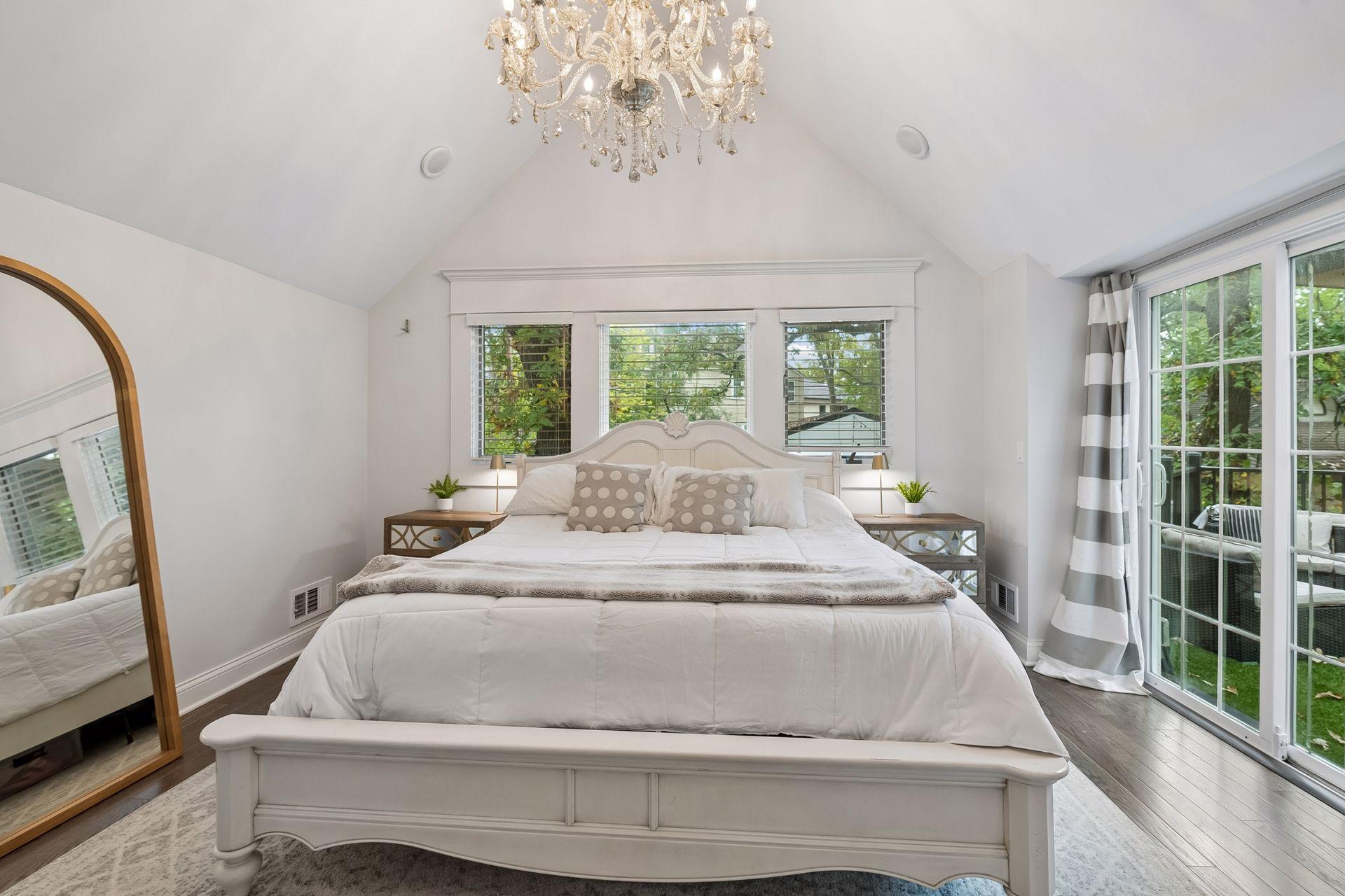 Vaulted primary suite features new wood flooring and abundant natural light.