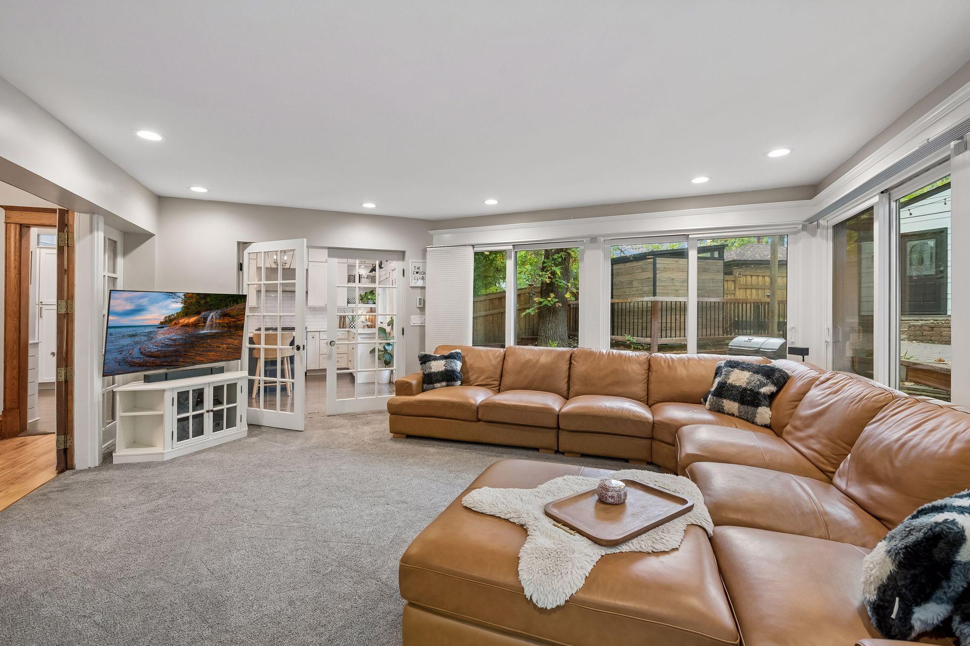 Spacious family room with custom shades and carpeting installed approximately one year ago.