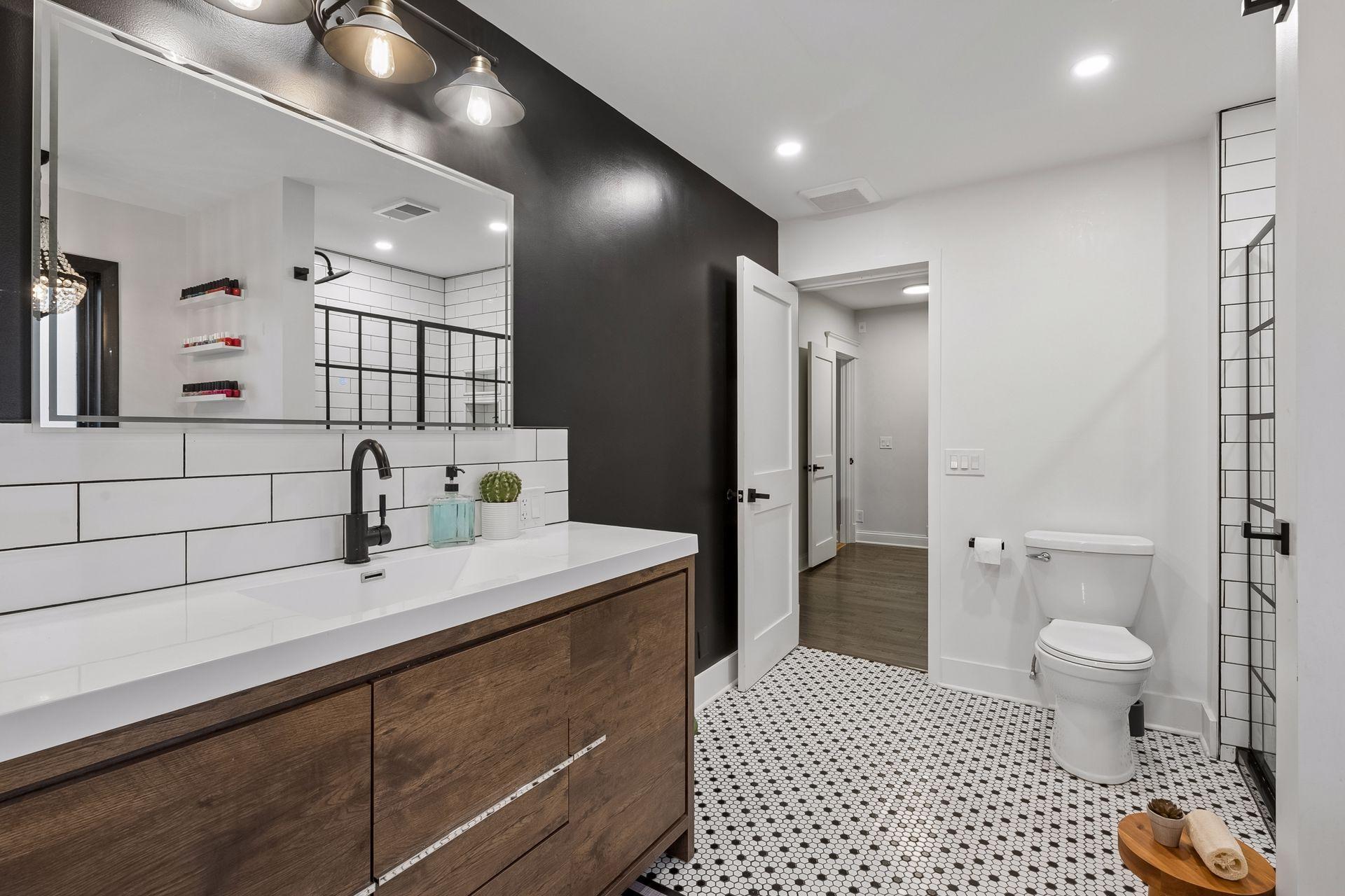 Updated primary bath with built-in dresser, modern vanity and extensive storage.