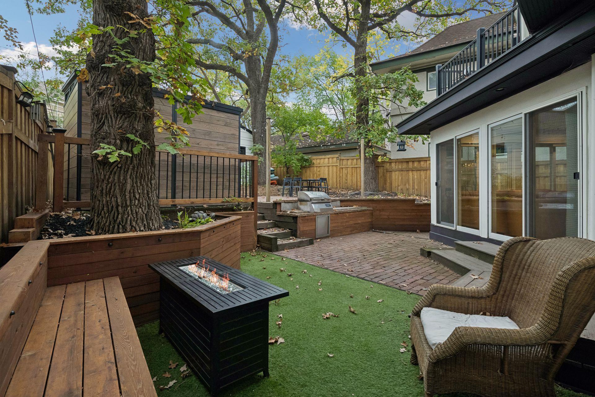 Fenced backyard, features artificial turf, brick, patio, and multiple gathering areas
