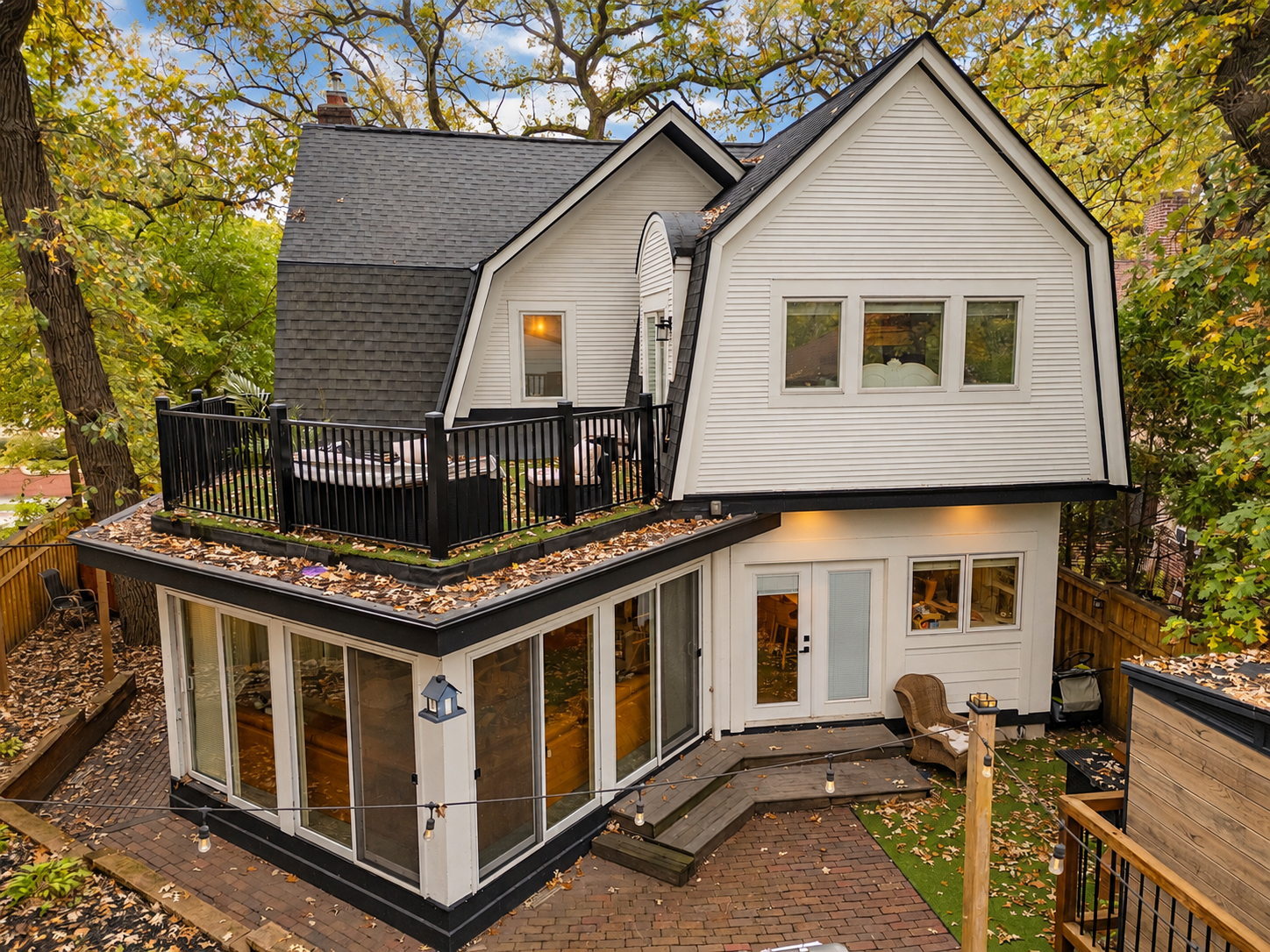 Updated rear exterior with newer woodwork, roofing, gutters and outdoor living spaces.