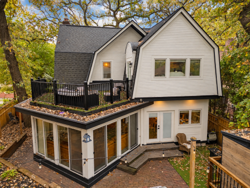 Updated rear exterior with newer woodwork, roofing, gutters and outdoor living spaces.
