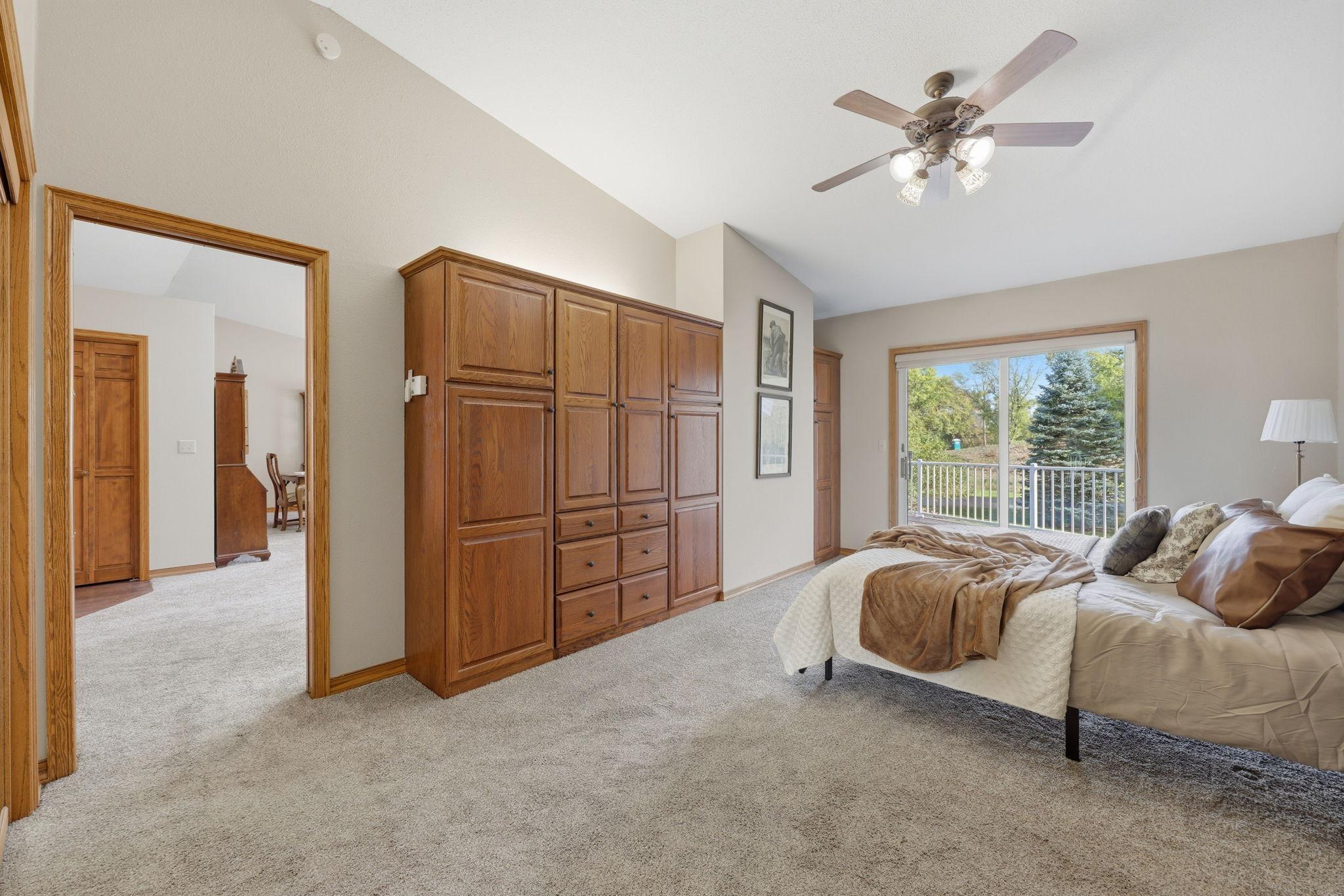 Primary suite overlooks the deck and peaceful outdoor green space. Built-in storage.