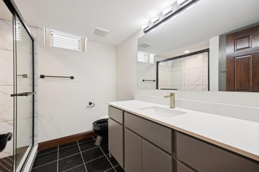 Lower level bathroom with ceramic tile and new cabinet and countertops