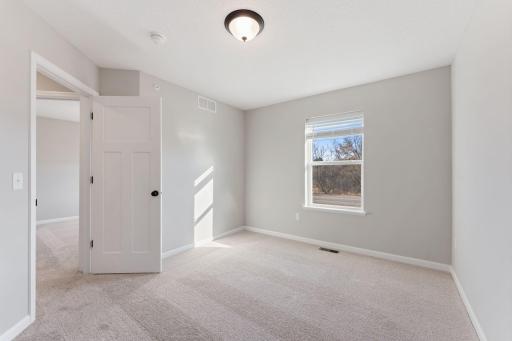 Welcoming secondary bedroom with space to make your own. Photo is for representational purposes only, not the actual home.