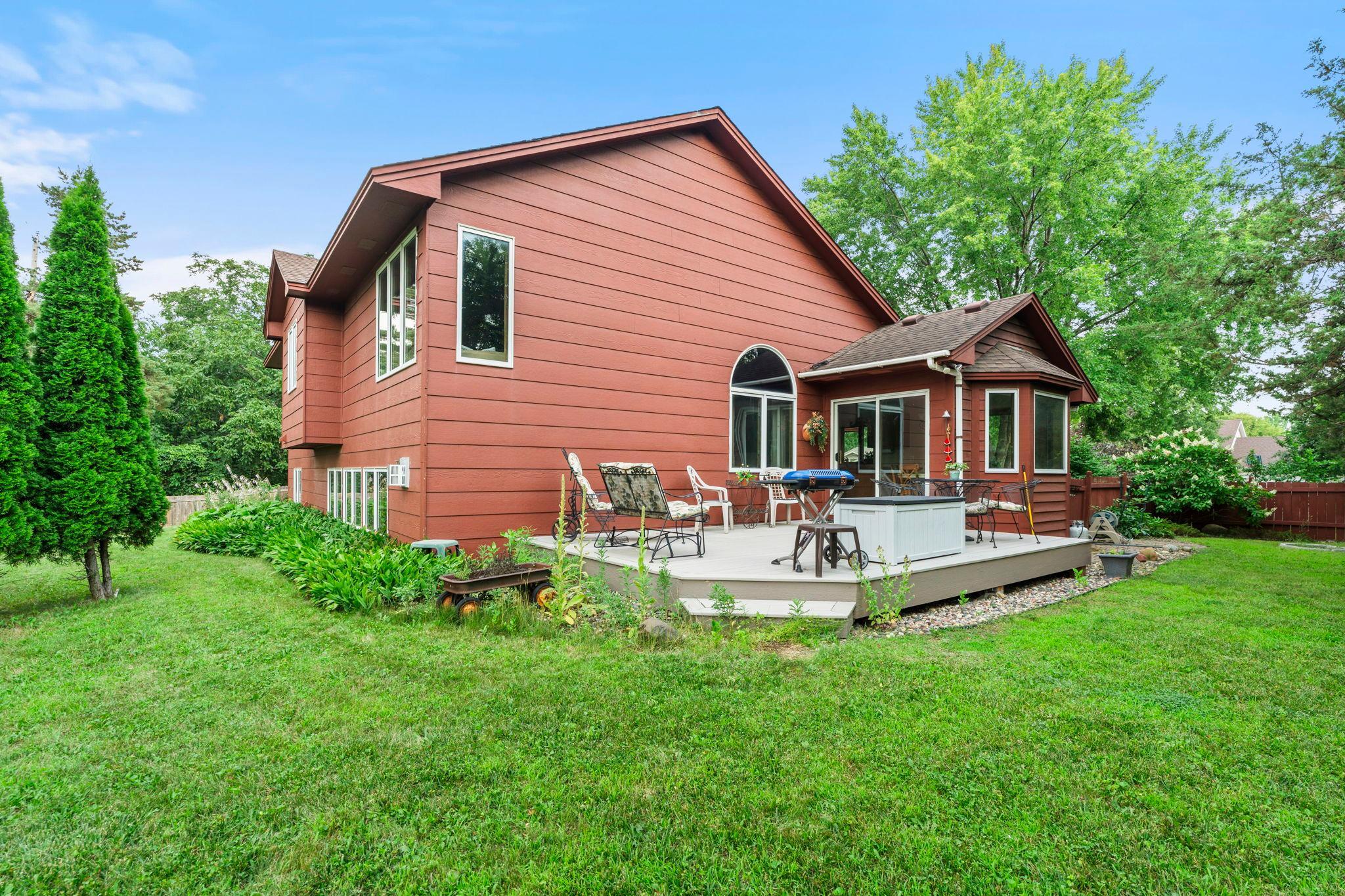 View of the back of the home and yard that wraps around the home, fenced backyard