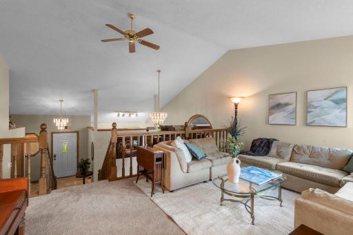Living room has vaulted ceilings, overlooks dining