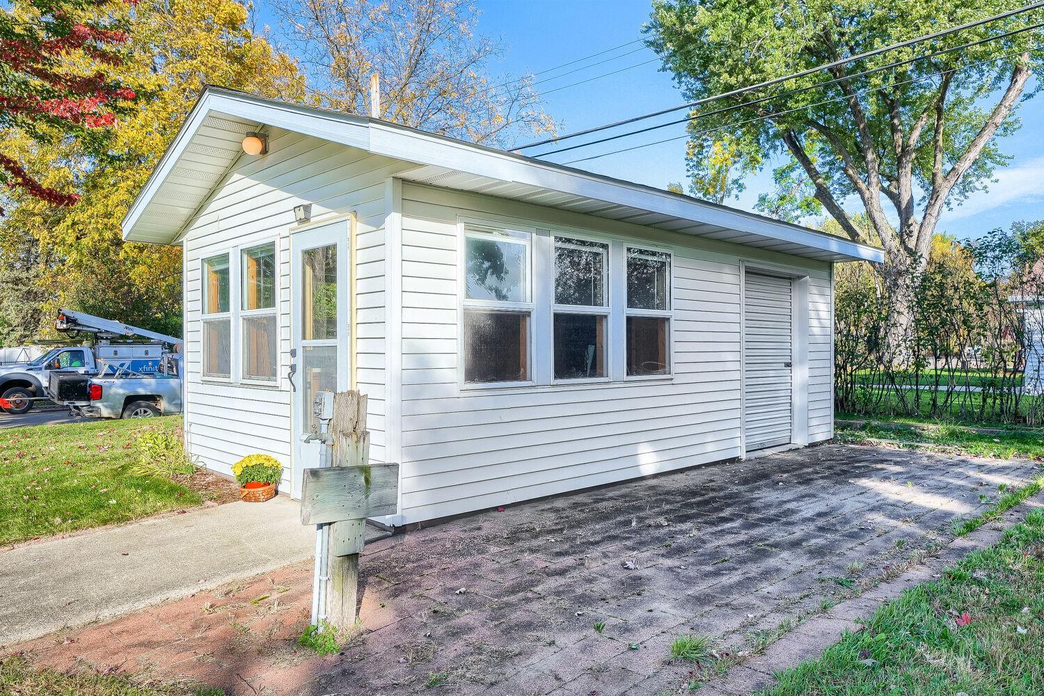 Garden Shed with electrical hookup and garage-style door with storage section for garden tractor and tools.