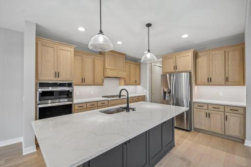 Spacious gourmet kitchen with large center island with cabinets on both front and back - finished off with gorgeous quartz countertops!