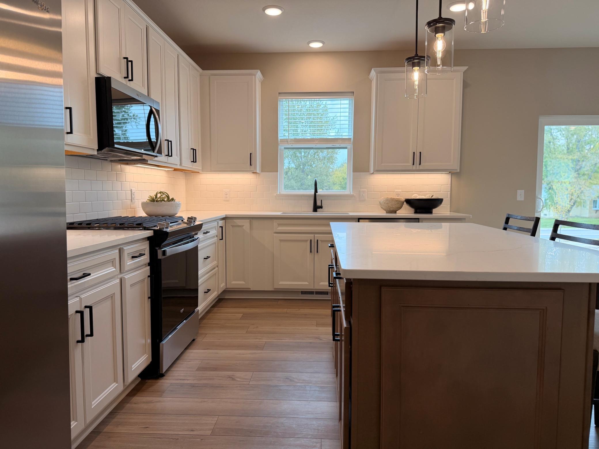 Central island offers additional prep space, seating, and storage, making it the heart of the home.