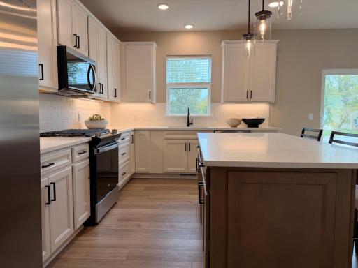Central island offers additional prep space, seating, and storage, making it the heart of the home.