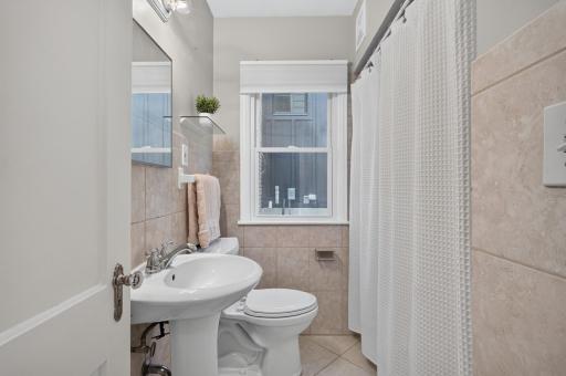 Main level full bathroom with a tiled shower