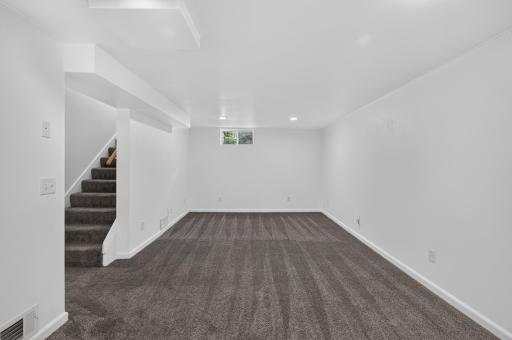 The lower level family room is spacious and features newer windows and plush carpet