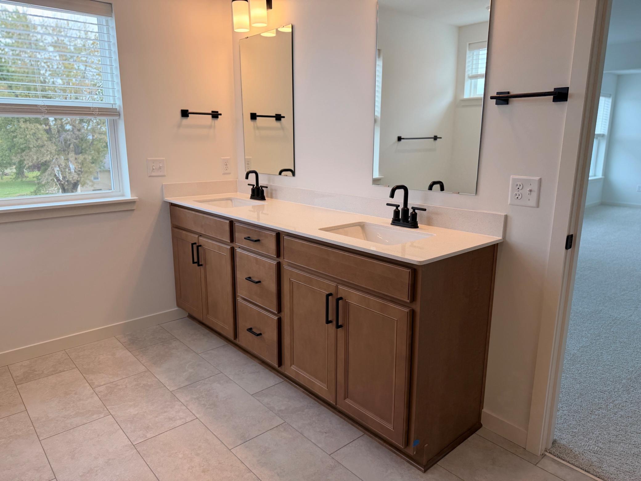 Double vanity with sleek countertops and ample storage provides both function and style—perfect for shared use while maintaining personal space.
