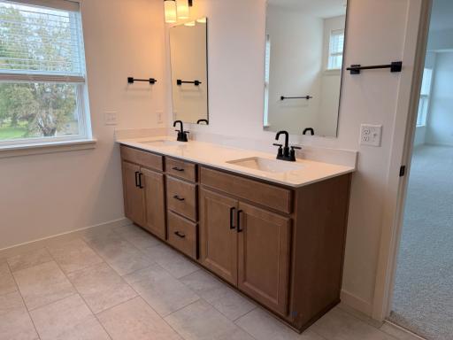 Double vanity with sleek countertops and ample storage provides both function and styleâperfect for shared use while maintaining personal space.