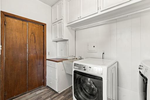 Large main level laundry room located right off the family room with tons of built in storage and utility sink!