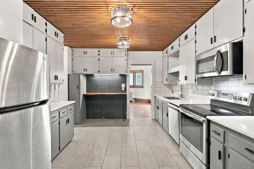 Updated kitchen with stainless steel appliances, tile flooring and accent ceiling to add texture and charm!