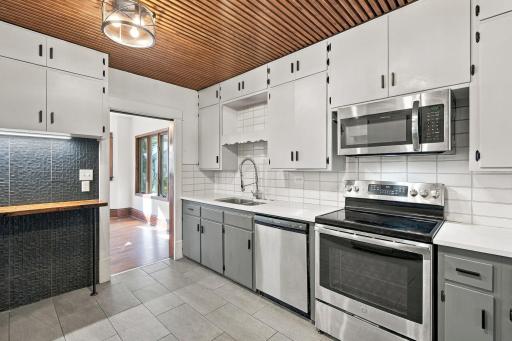 Updated kitchen with stainless steel appliances, tile flooring and accent ceiling to add texture and charm!