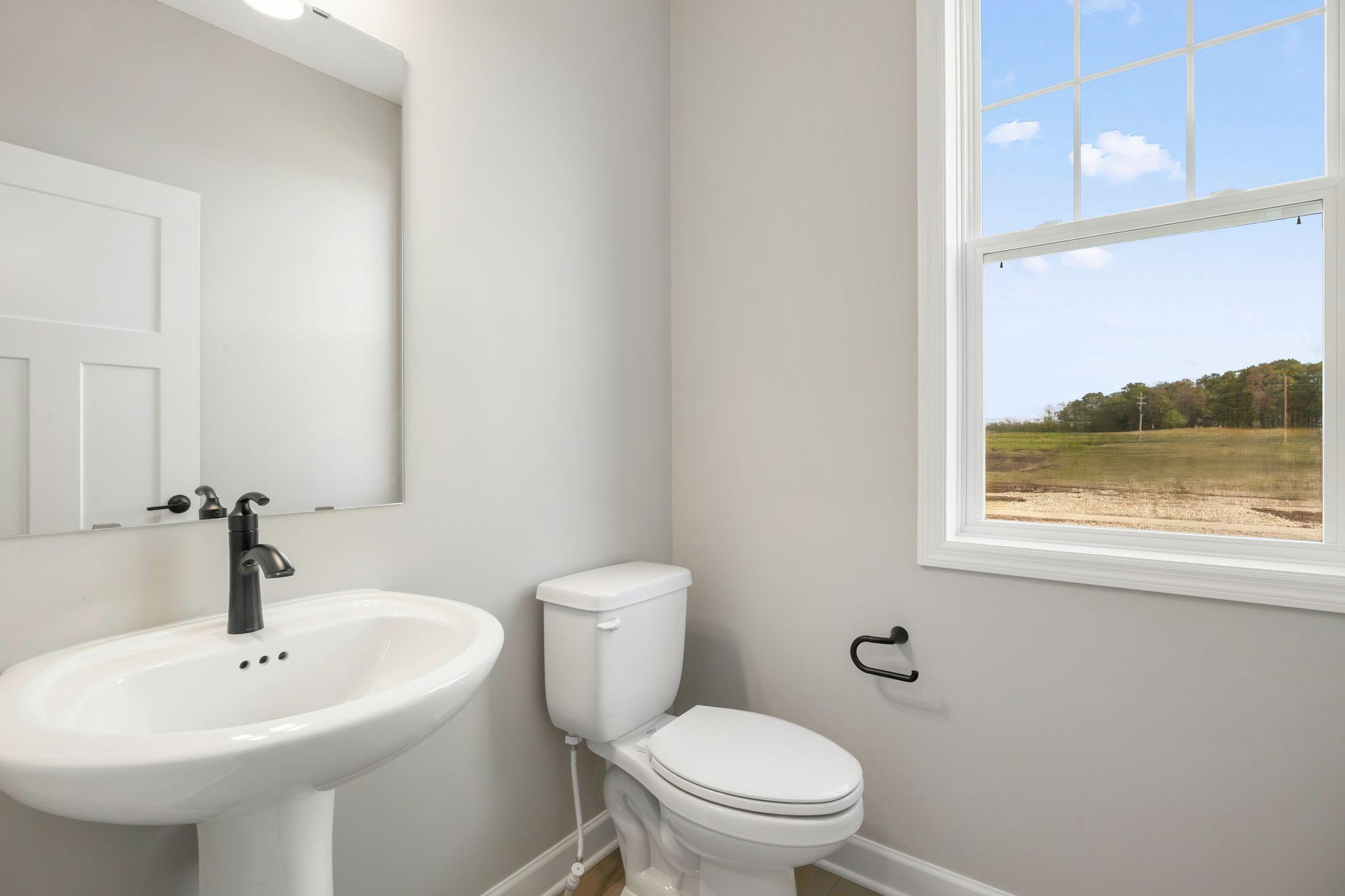 Conveniently placed near the Great Room, the powder room is conveniently trucked away with privacy in mind.