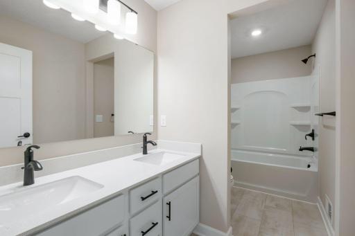 This full bathroom is conveniently located on the second floor and showcases dual sinks and a shower-tub combination.