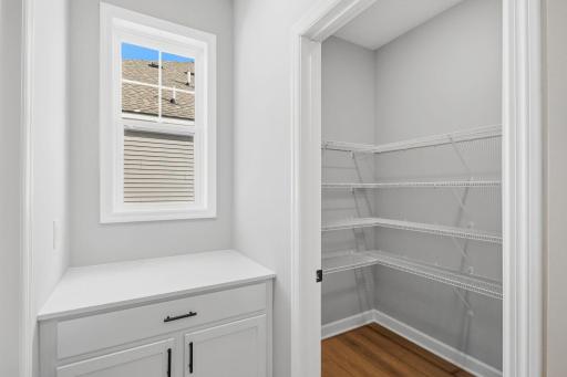 The laundry room with mesh shelving provides much needed storage space