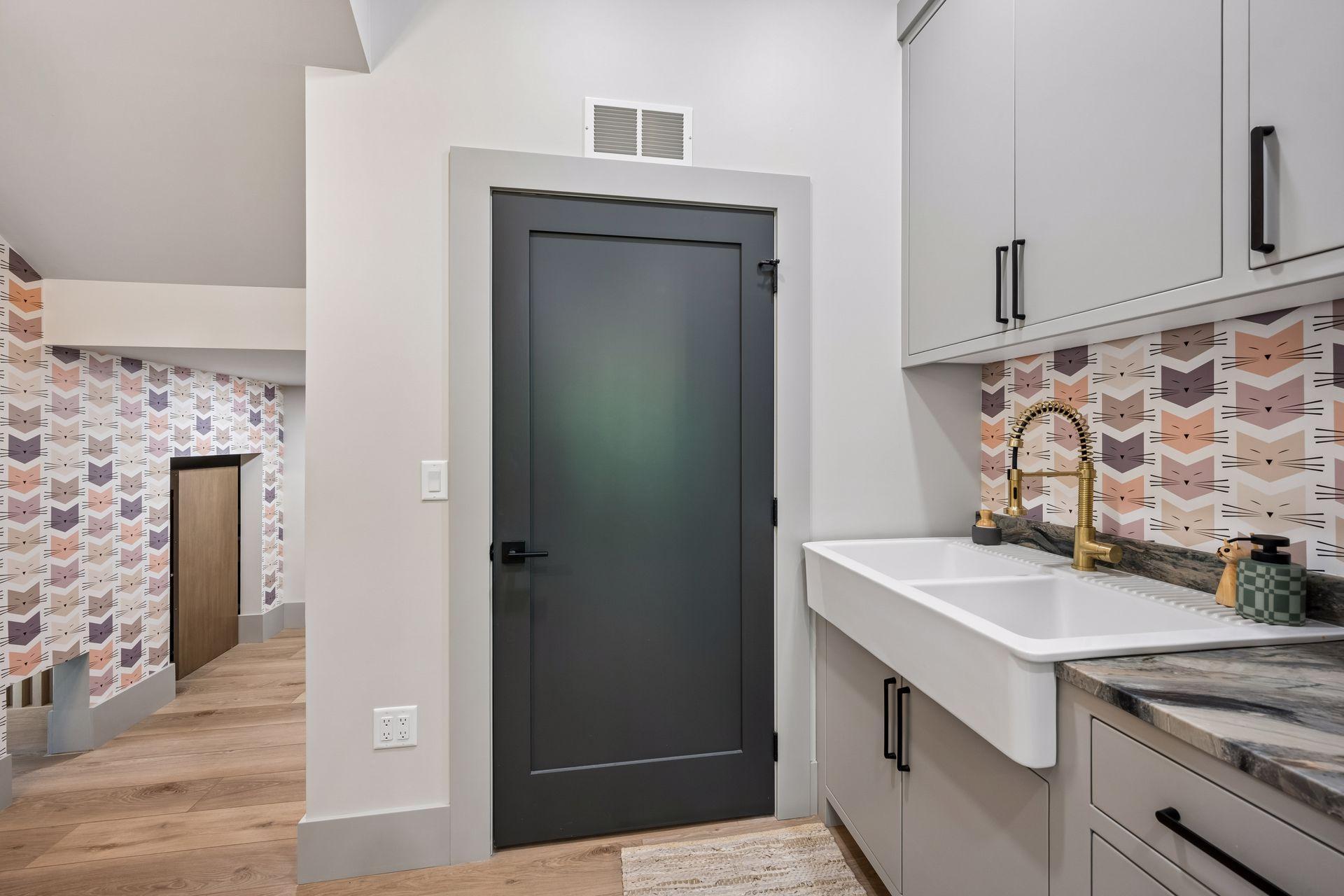 Designer wallpaper starts in the Utility/Storage room and continues throughout the home. Enjoy the convenience of a large utility sink and extra storage space.