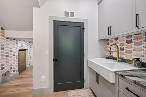 Designer wallpaper starts in the Utility/Storage room and continues throughout the home. Enjoy the convenience of a large utility sink and extra storage space.