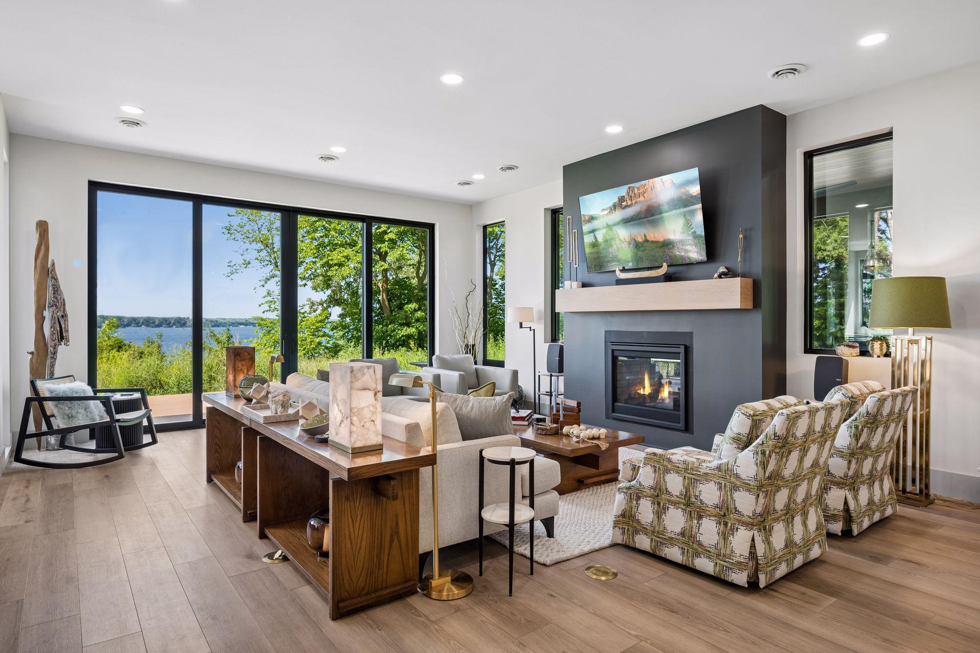 Natural light pours through expansive windows and sliding glass doors, creating a bright and inviting living space highlighted by beautiful lake views.