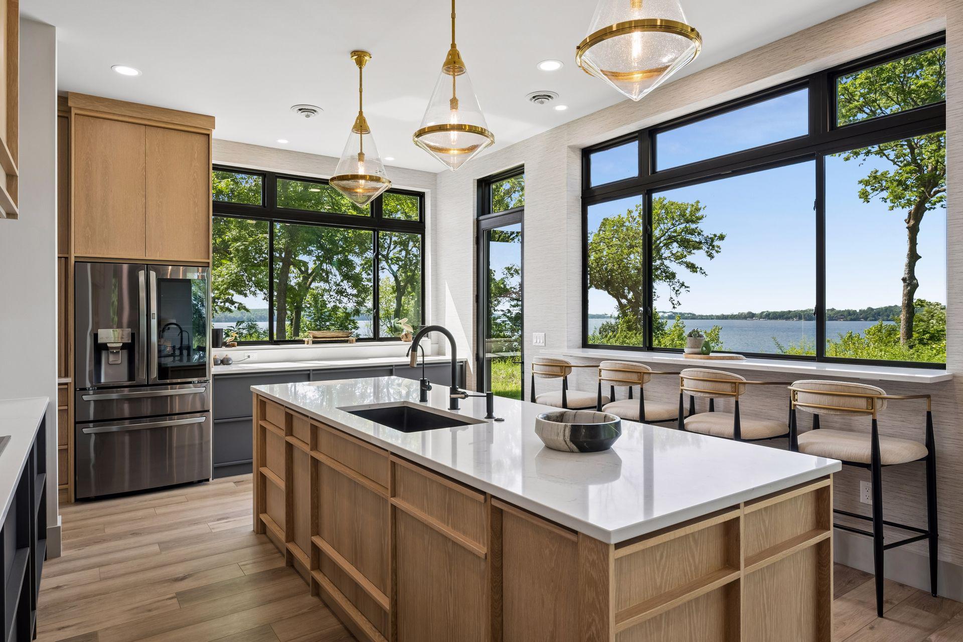 Expansive windows frame picturesque lake views while filling the space with natural light, creating an inviting setting for cooking, gathering, and entertaining.