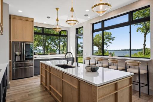 Expansive windows frame picturesque lake views while filling the space with natural light, creating an inviting setting for cooking, gathering, and entertaining.