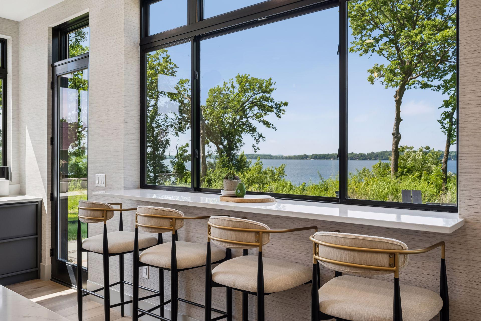 A built-in breakfast bar stretches beneath expansive windows, creating the perfect perch to enjoy casual meals, or conversation while taking in breathtaking lake views.