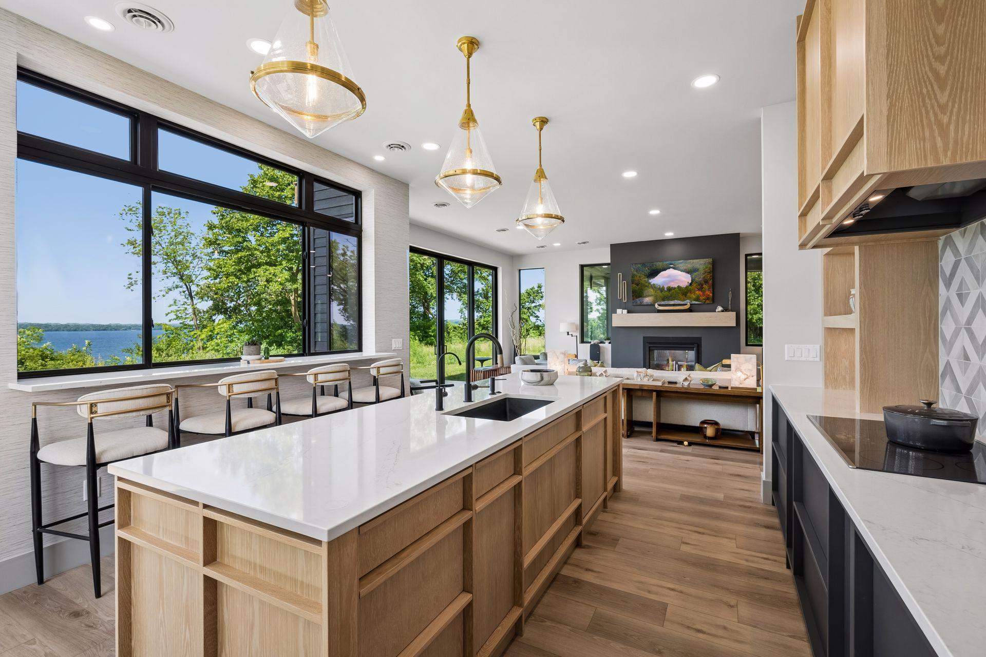 Flooded with natural light, this inviting kitchen seamlessly connects the indoors with the beauty of the surrounding landscape while perched above the lake.
