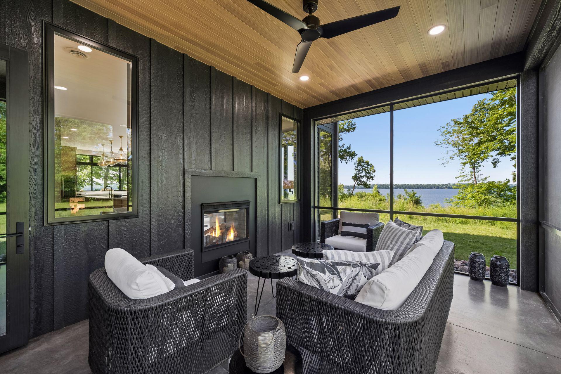 The screened porch offers a peaceful retreat to enjoy the sights and sounds of the lake, featuring a stunning see-through fireplace shared with the living space.