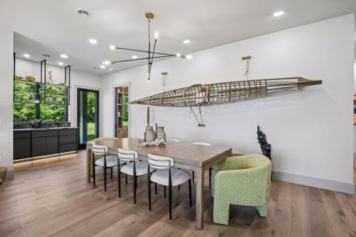 The dining room offers an inviting setting for everything from casual meals to holiday gatherings, with ample space for guests and seamless access to the serving bar.