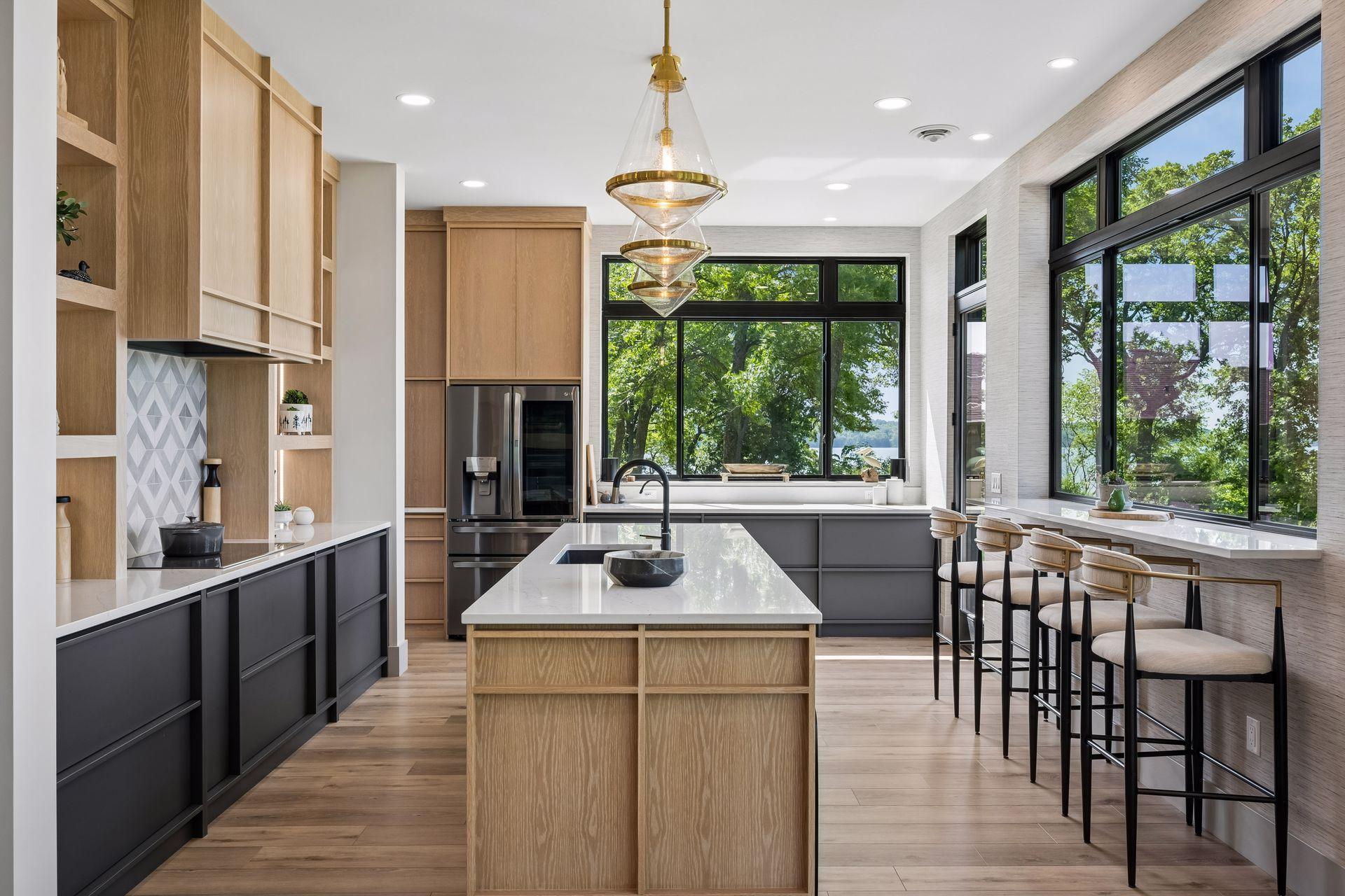 The beautifully appointed kitchen blends form and function with clean lines, custom cabinetry, breakfast bar and a spacious center island with sink.