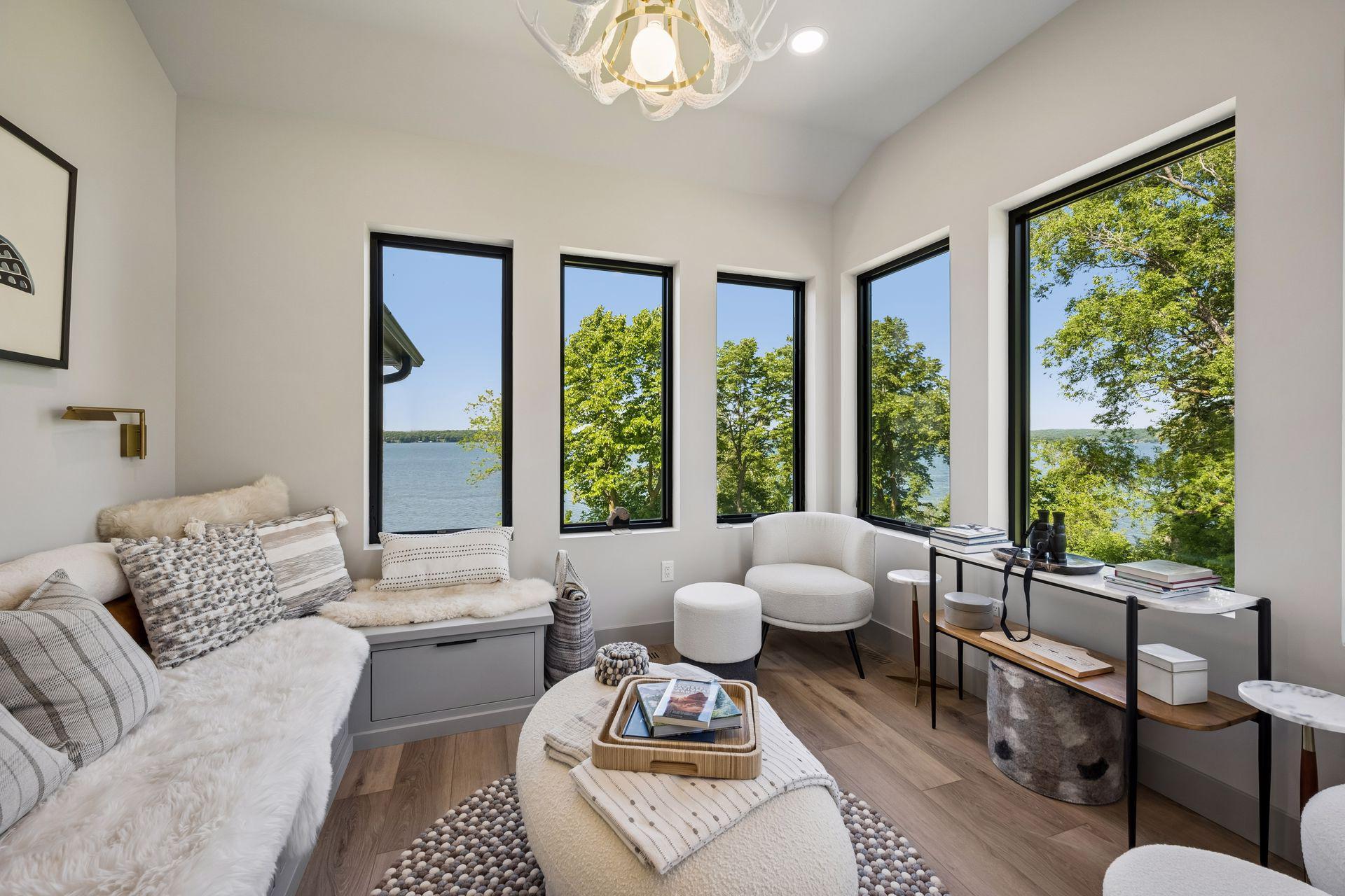 Perched above the main living spaces, the elevated "Cozy Nest" sunroom is a one-of-a-kind retreat designed for relaxation and surrounded by panoramic lake views.