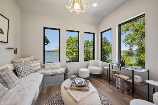 Perched above the main living spaces, the elevated "Cozy Nest" sunroom is a one-of-a-kind retreat designed for relaxation and surrounded by panoramic lake views.