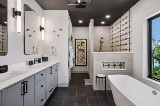 The spa-inspired primary bath is designed as a private sanctuary, featuring a freestanding soaking tub perfectly positioned to capture breathtaking lake views.