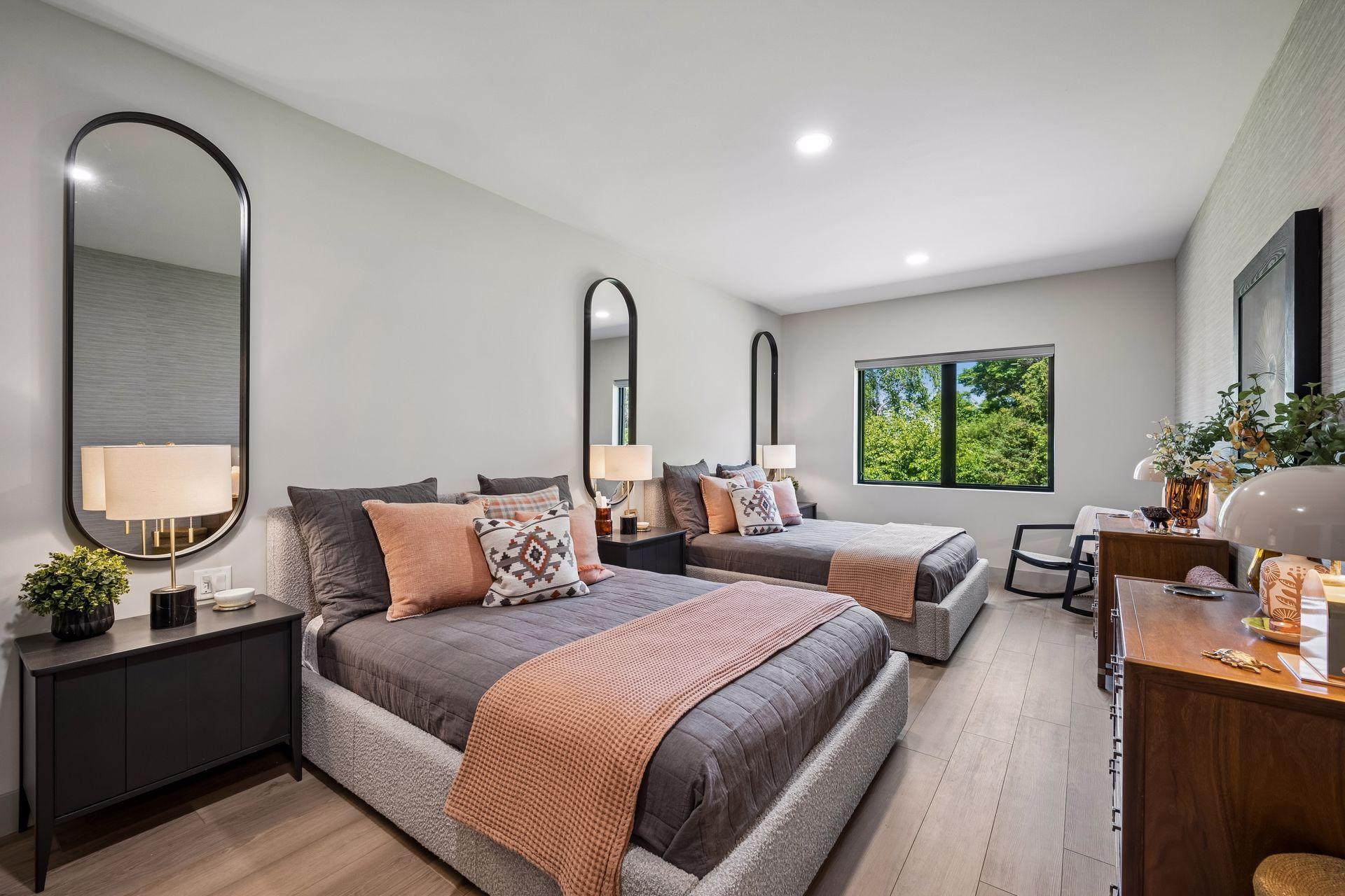This spacious guest bedroom offers a retreat for family and friends, with ample room for 2 queen beds and a large window that bring in natural light and peaceful treetop views.