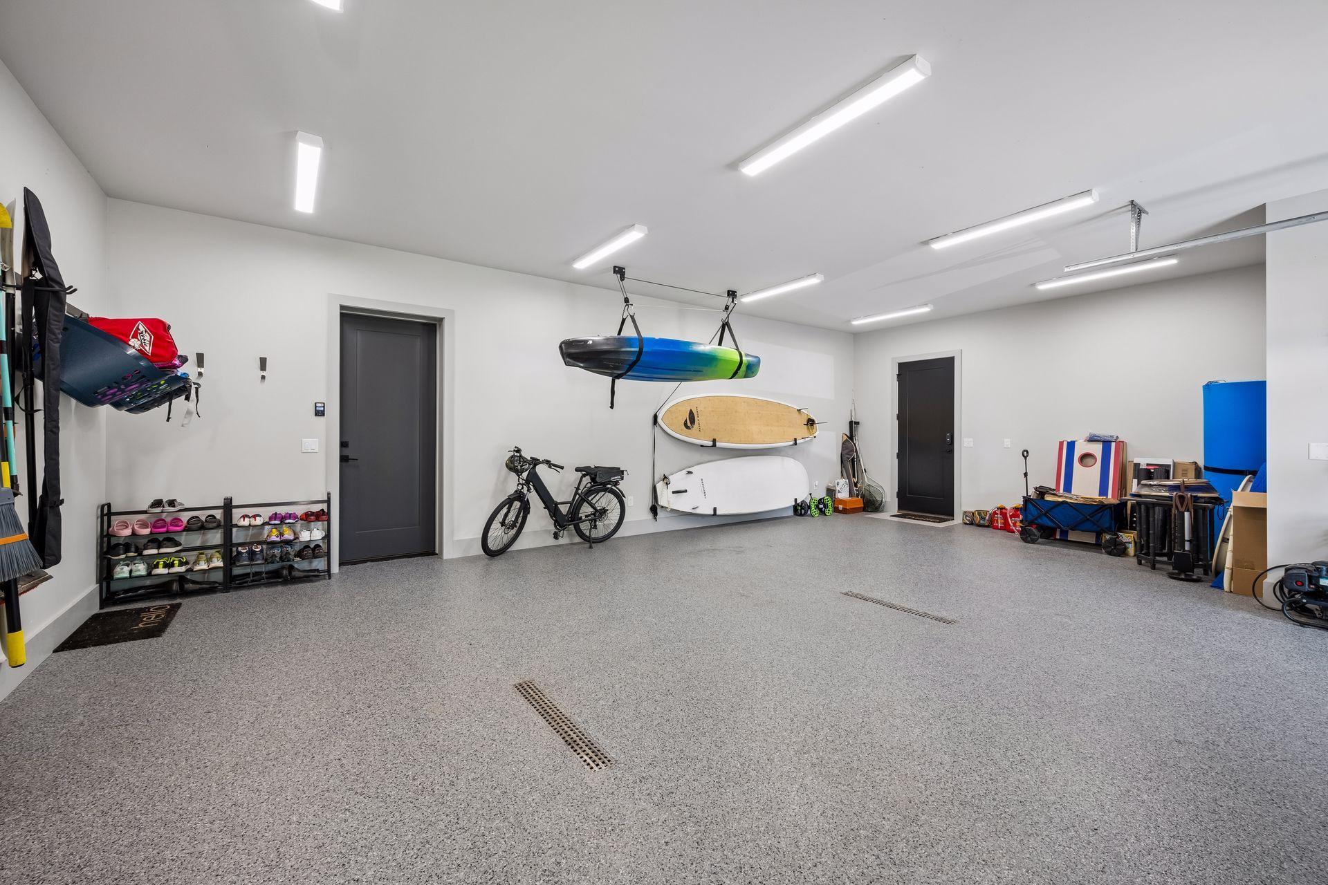 The oversized garage is thoughtfully designed for lake living, featuring durable epoxy flooring, convenient floor drain and a dedicated 'lake gear' storage area.