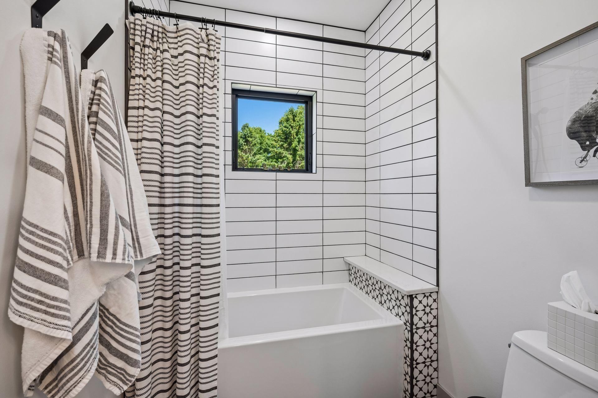 The spa-like bathroom features a dual-sink vanity, designer tilework, and a thoughtfully designed tub and shower area - what more do you need?