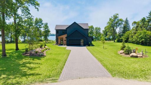 The striking Scandinavian-inspired exterior makes a bold first impression with clean architectural lines, dark siding, and warm wood accents that blend beautifully with the natural surroundings.
