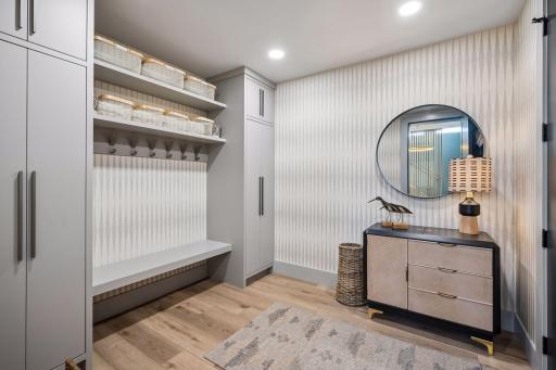 The thoughtfully designed mudroom combines style and function with custom built-in cabinetry, open storage, and a convenient bench for everyday organization. This room also doubles as a storm shelter.